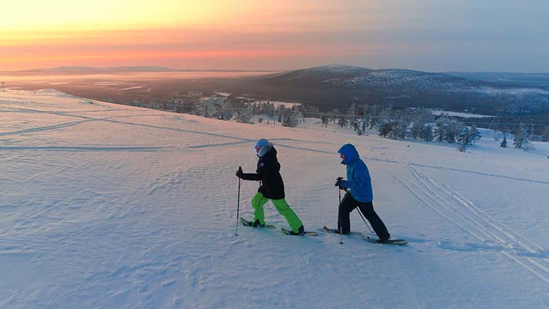 Kaksi lumikenkäilijää Lapissa